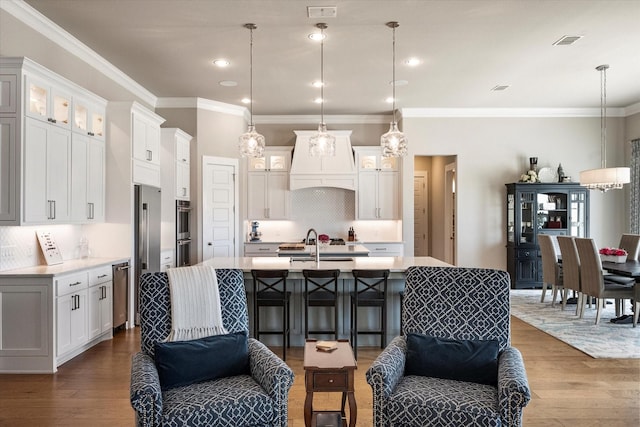 kitchen featuring open floor plan, light countertops, visible vents, and wood finished floors