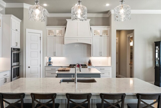 dining area featuring ceiling fan, ornamental molding, sink, and light wood-type flooring