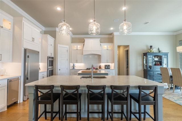 kitchen with pendant lighting, a large island, custom exhaust hood, and appliances with stainless steel finishes