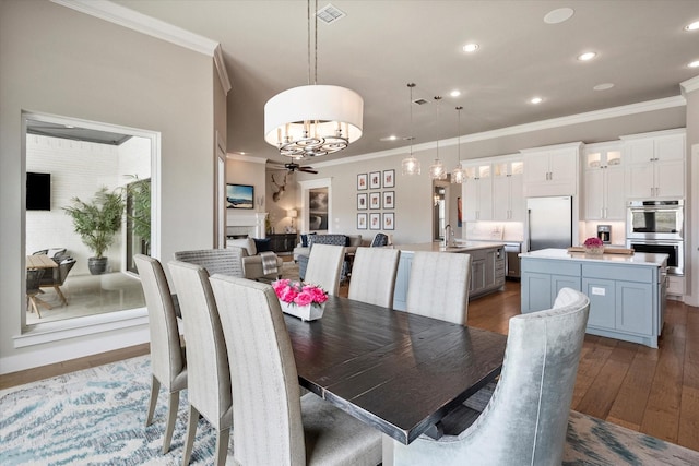 dining area featuring dark wood-style floors, a ceiling fan, crown molding, and recessed lighting