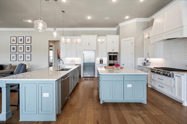 kitchen featuring stainless steel appliances, dark wood-type flooring, a sink, and a large island