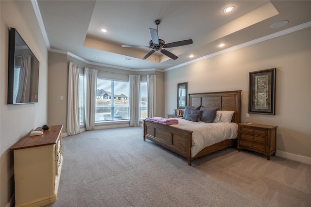 bedroom with crown molding, light carpet, ceiling fan, and a tray ceiling