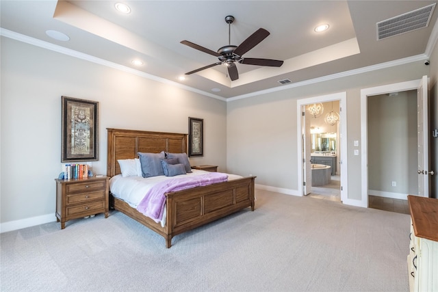 bedroom featuring ensuite bathroom, crown molding, light carpet, a tray ceiling, and ceiling fan