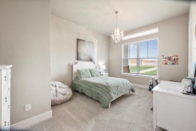 bedroom featuring a chandelier, carpet, and baseboards