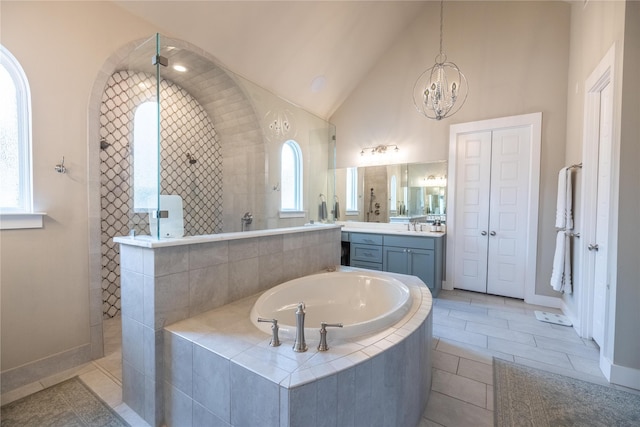 bathroom featuring tile patterned flooring, vanity, high vaulted ceiling, and plus walk in shower