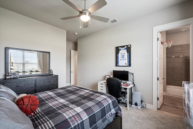 carpeted bedroom featuring ensuite bath, visible vents, and a ceiling fan