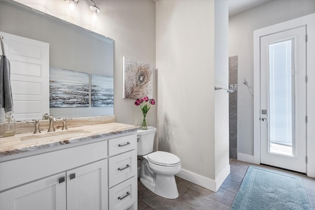 bathroom featuring tile patterned floors, vanity, toilet, and baseboards