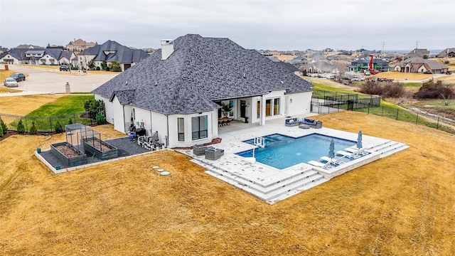 view of pool with a patio area, a fire pit, and a lawn