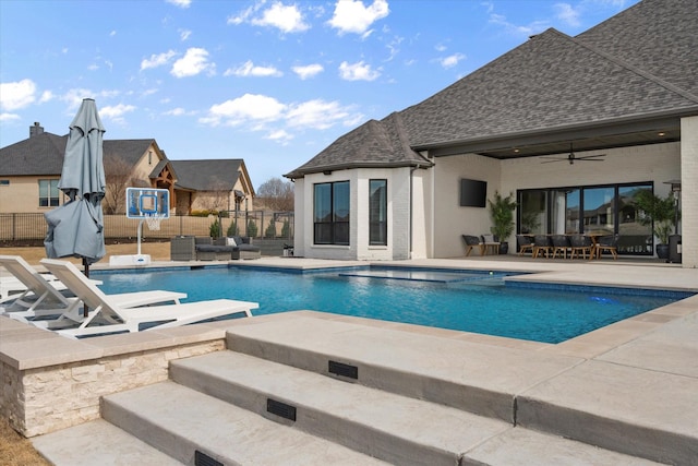 view of swimming pool featuring a fenced in pool, a patio area, ceiling fan, and fence