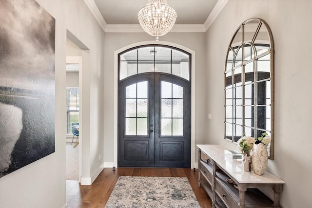 foyer entrance featuring crown molding, a chandelier, hardwood / wood-style floors, and french doors