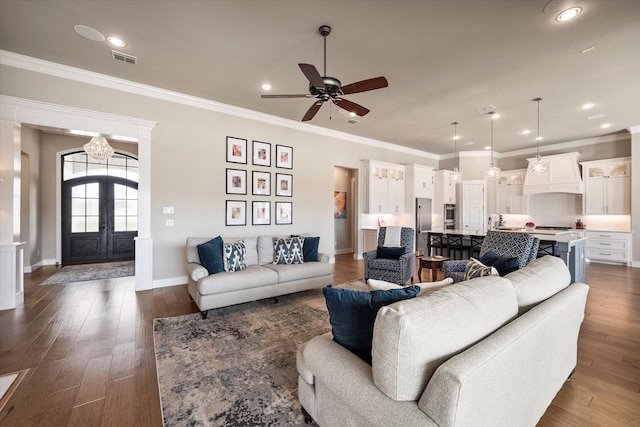 living room featuring french doors, dark wood-style flooring, visible vents, and crown molding