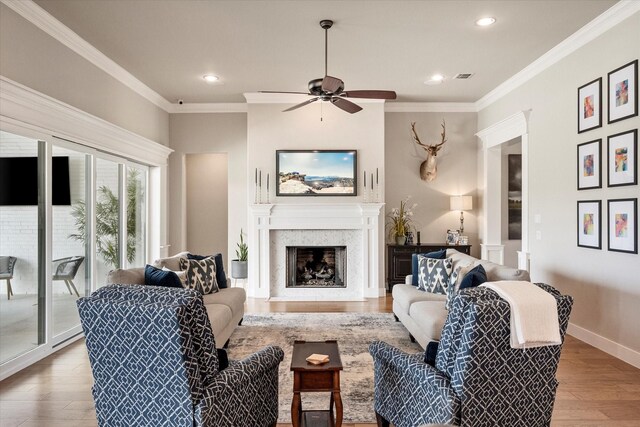 living room featuring crown molding, ceiling fan, and light hardwood / wood-style flooring