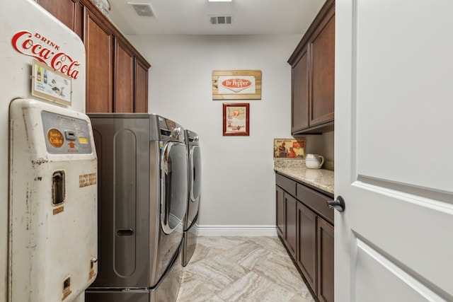 clothes washing area with cabinets and independent washer and dryer