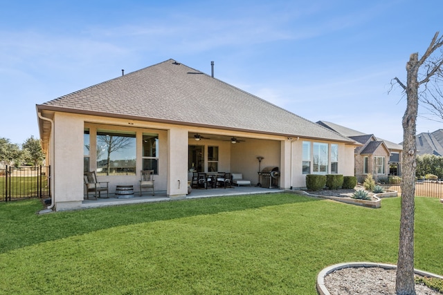 rear view of property featuring ceiling fan, a yard, and a patio area