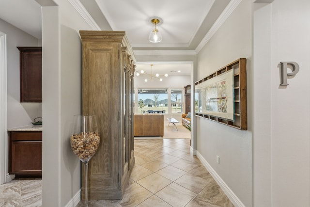 corridor featuring ornamental molding, a chandelier, and light tile patterned floors