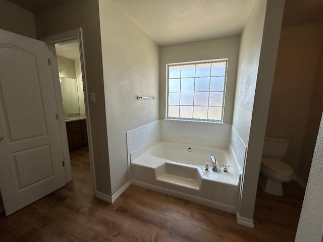 bathroom featuring a bath, wood-type flooring, and toilet