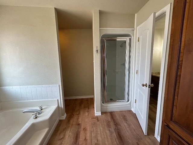 bathroom featuring wood-type flooring and independent shower and bath