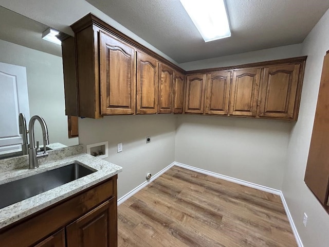 clothes washing area featuring sink, electric dryer hookup, hookup for a washing machine, cabinets, and hookup for a gas dryer