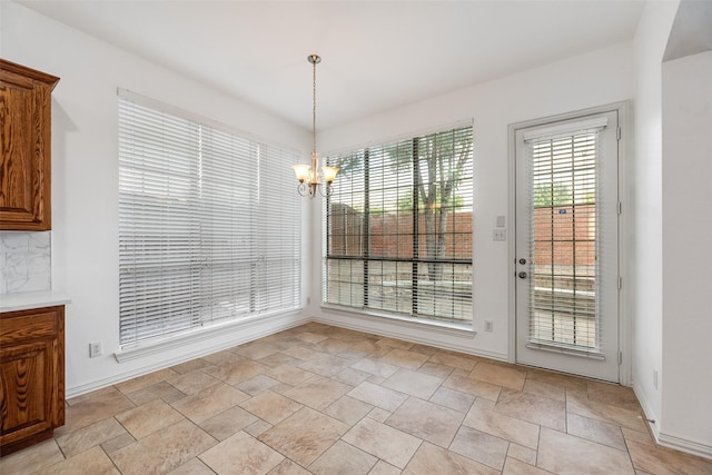 9328 Old Veranda Rd, Plano, TX 75024 - unfurnished dining area featuring stone finish floors, a chandelier, and baseboards