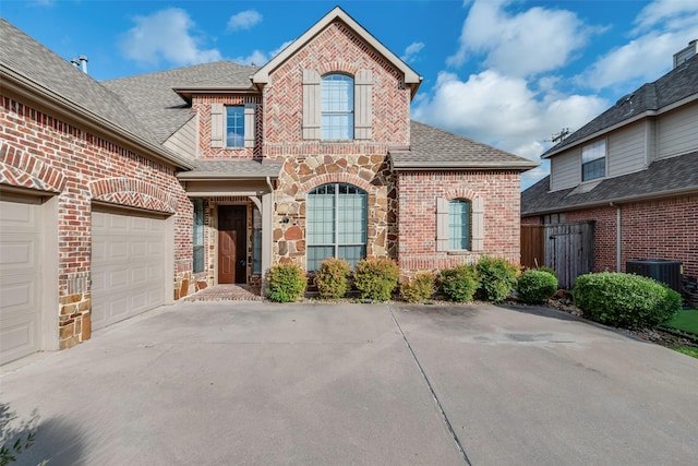 9328 Old Veranda Rd, Plano, TX 75024 - view of front of home with concrete driveway, brick siding, central AC, a shingled roof, and an attached garage