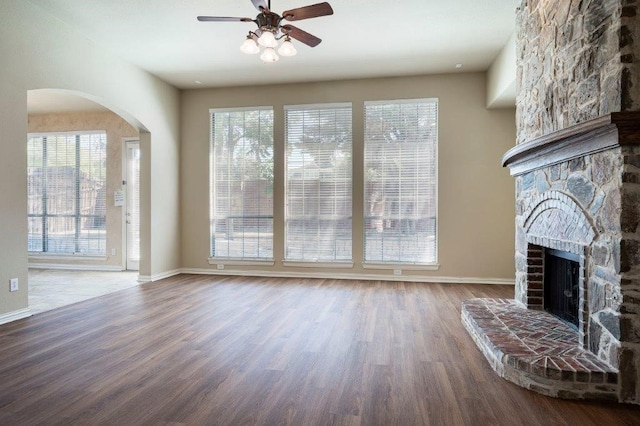 living room featuring hardwood / wood-style flooring, a large fireplace, and ceiling fan