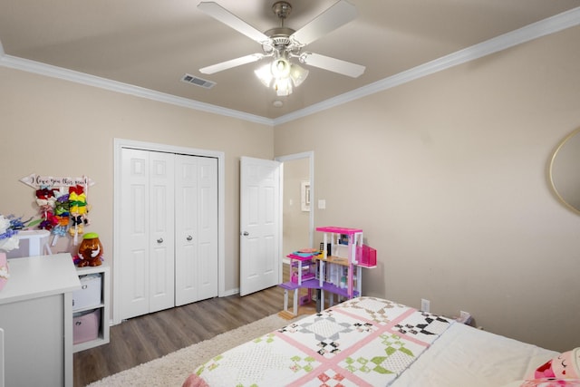 bedroom with dark hardwood / wood-style flooring, crown molding, a closet, and ceiling fan