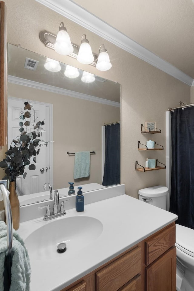 bathroom with ornamental molding, toilet, and vanity