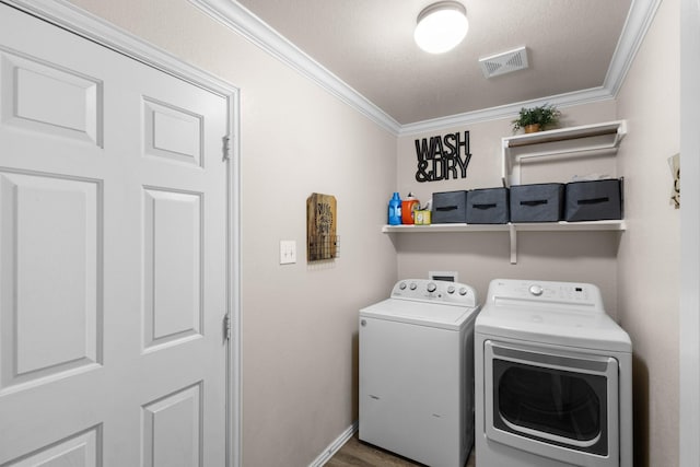 clothes washing area with crown molding and separate washer and dryer