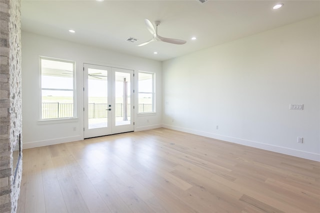 unfurnished room with ceiling fan, light wood-type flooring, and french doors