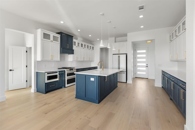 kitchen with white cabinetry, stainless steel appliances, and blue cabinetry