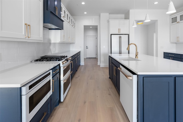 kitchen with pendant lighting, sink, white appliances, white cabinets, and blue cabinets