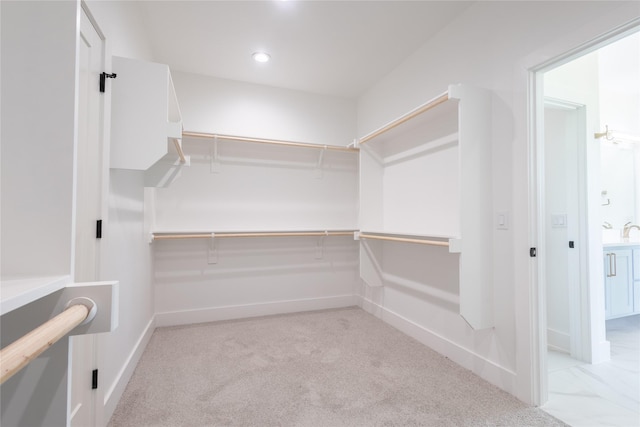 walk in closet featuring light colored carpet