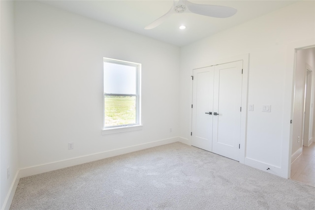 unfurnished bedroom featuring ceiling fan, a closet, and light carpet