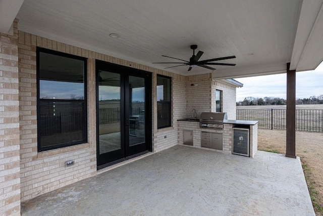 view of patio with an outdoor kitchen, sink, area for grilling, ceiling fan, and beverage cooler