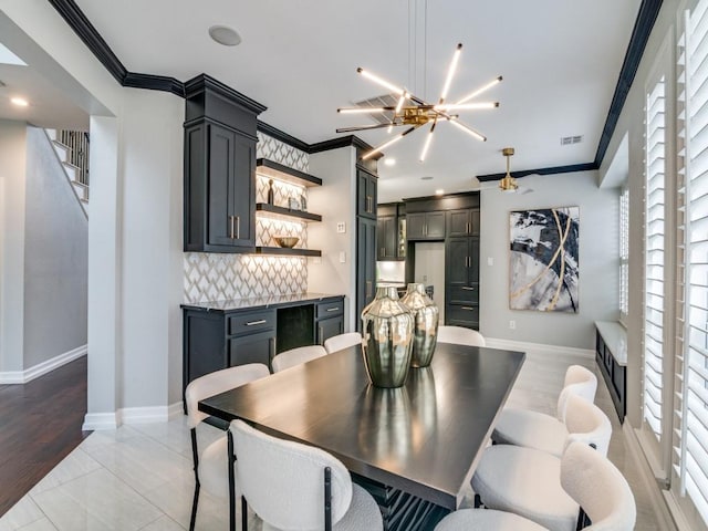 dining area with an inviting chandelier, crown molding, and a healthy amount of sunlight