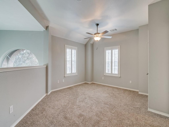 carpeted spare room featuring lofted ceiling and ceiling fan