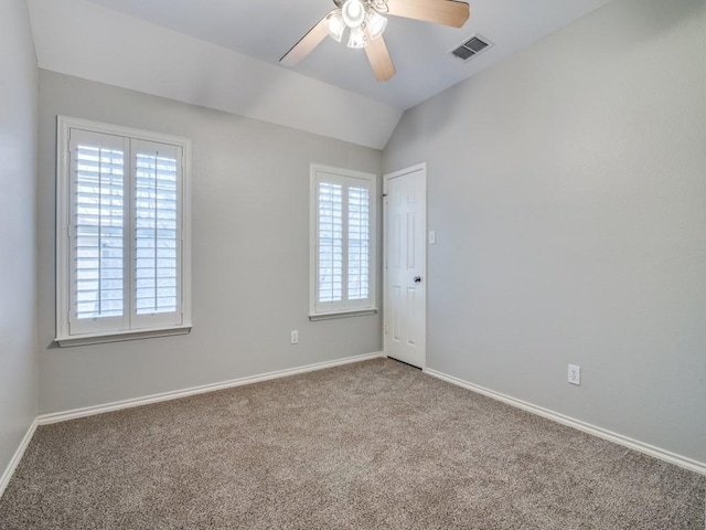 carpeted spare room featuring lofted ceiling and ceiling fan