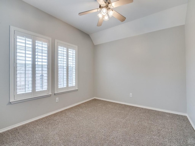 carpeted empty room featuring vaulted ceiling and ceiling fan