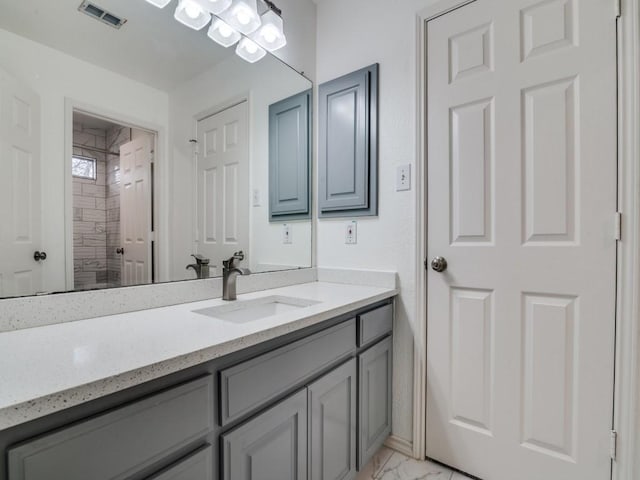 bathroom featuring vanity and tiled shower