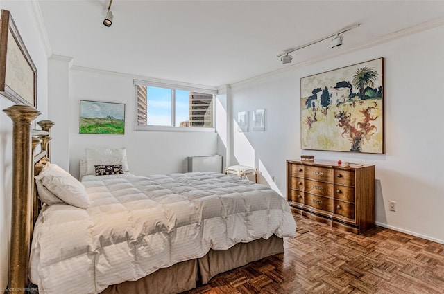 bedroom featuring parquet floors, track lighting, and ornamental molding