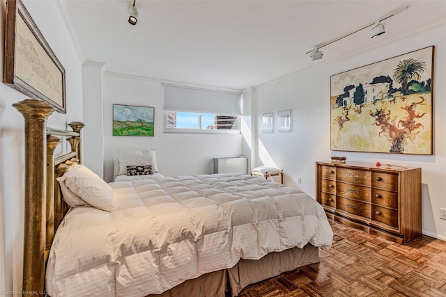 bedroom featuring ornamental molding, parquet flooring, and track lighting