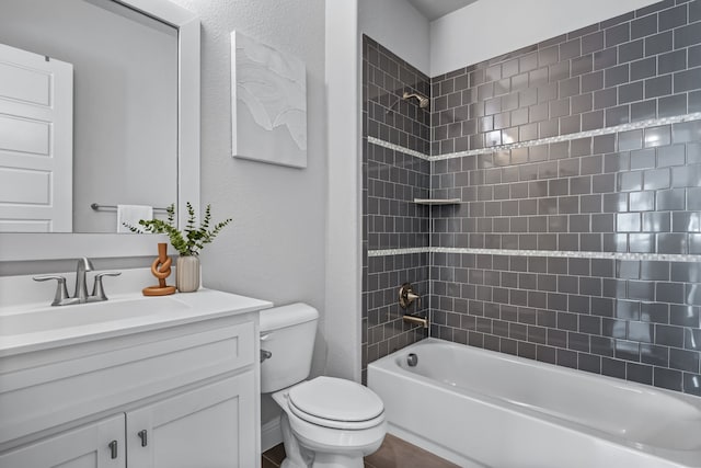 full bathroom with tiled shower / bath, vanity, and toilet