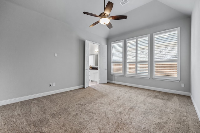 unfurnished bedroom featuring vaulted ceiling, ceiling fan, connected bathroom, and carpet floors