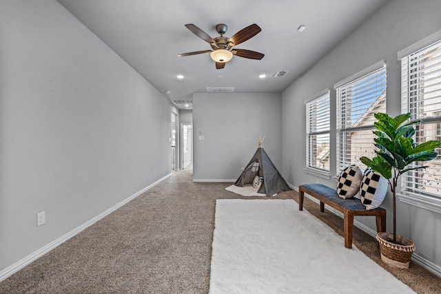 living area featuring carpet floors and ceiling fan