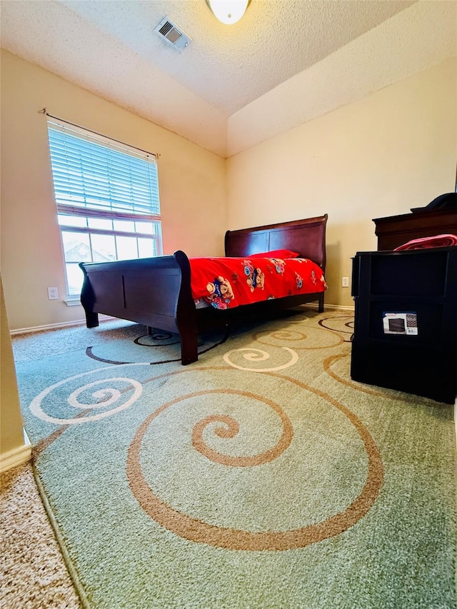 bedroom featuring carpet flooring, vaulted ceiling, and a textured ceiling