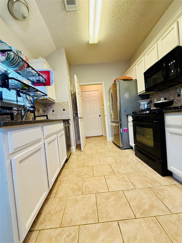 kitchen with light tile patterned floors, white cabinetry, backsplash, dark stone countertops, and black appliances