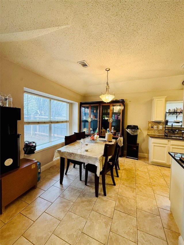 tiled dining room with a textured ceiling