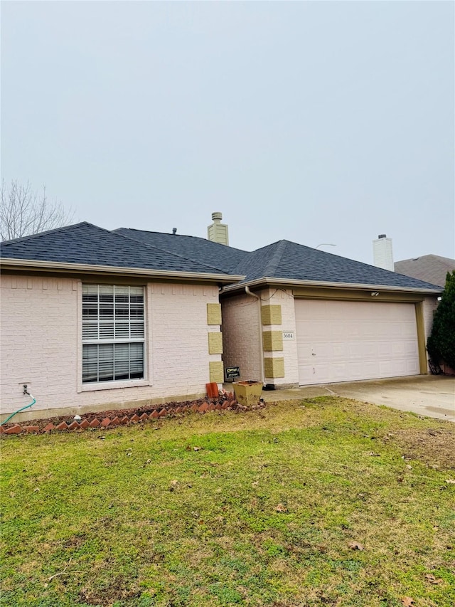 view of front of home featuring a garage and a front lawn