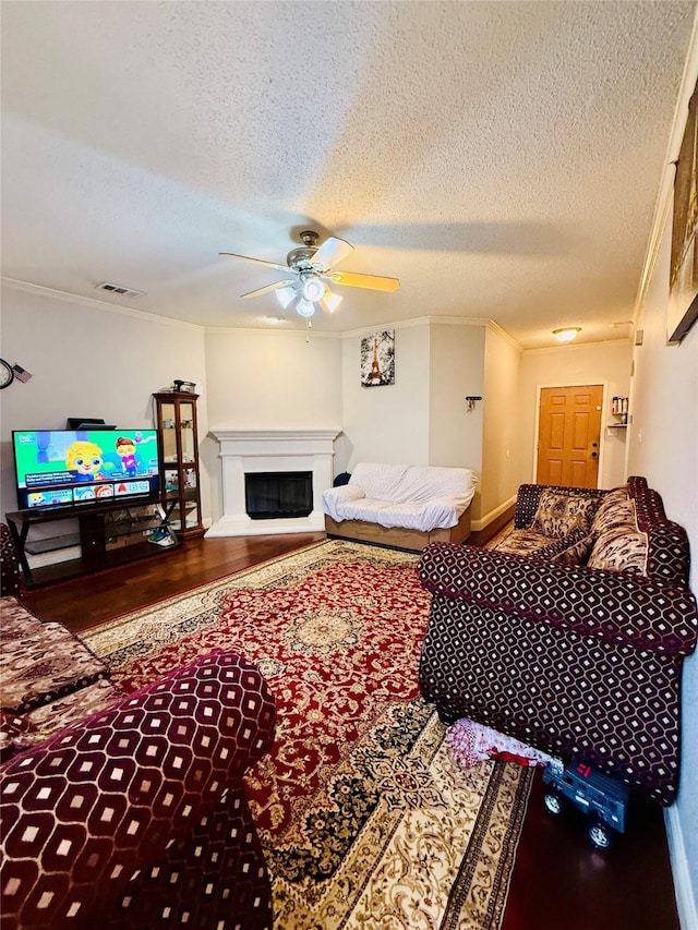 living room featuring crown molding, a textured ceiling, ceiling fan, and hardwood / wood-style flooring