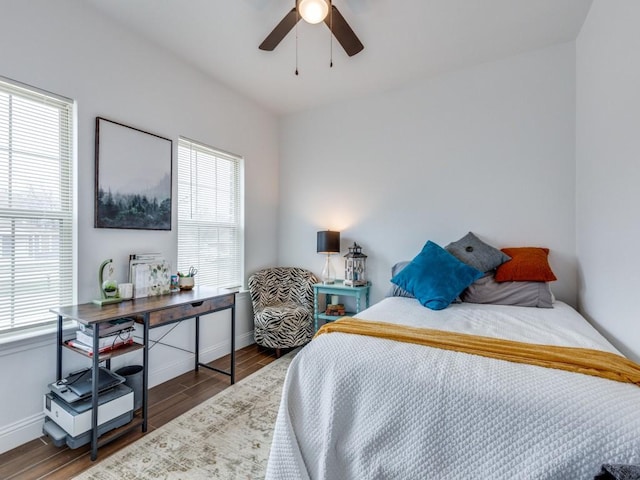 bedroom with multiple windows, dark wood-type flooring, and ceiling fan